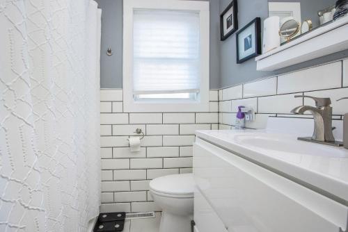 a white bathroom with a sink and a toilet at Boho cozy home, quiet, free parking (private room unless specified) in Kalamazoo