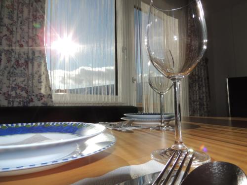 a table with two wine glasses on a wooden table at Haus Bergfried in Filzmoos