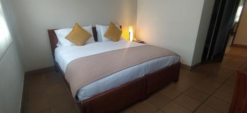 a small bed in a room with a light at Hotel Xue Sabana in Cajicá
