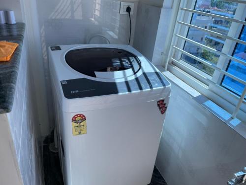 a washing machine sitting in a room next to a window at SAGAR NIWAS-1BHK and 2BHK short stay flats - NH HCL EC Bommasandra in Bengaluru