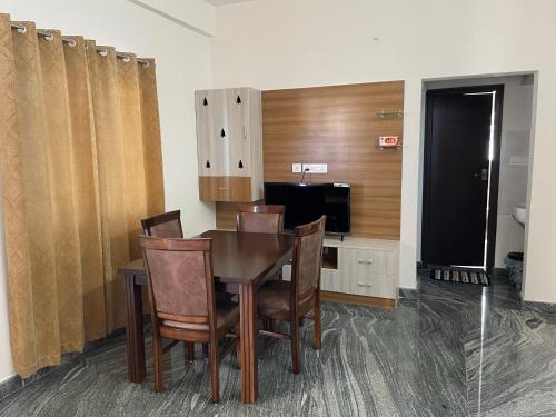 a dining room with a table and chairs and a television at SAGAR NIWAS-1BHK and 2BHK short stay flats - NH HCL EC Bommasandra in Bengaluru