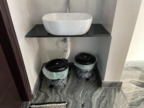 a bathroom with two trash cans under a sink at SAGAR NIWAS-1BHK and 2BHK short stay flats - NH HCL EC Bommasandra in Bengaluru