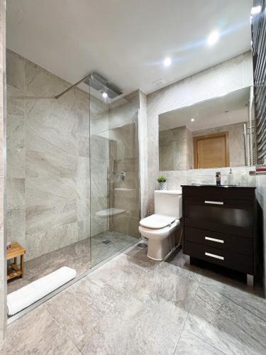 een badkamer met een douche, een toilet en een wastafel bij El Olivar de Las Rozas in Las Rozas de Madrid