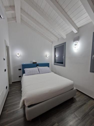 ein Schlafzimmer mit einem großen Bett in einem weißen Zimmer in der Unterkunft Bellagio Il Crotto in Bellagio