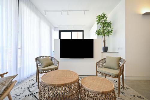 a living room with two chairs and a tv at Good times by HolyGuest in Tel Aviv