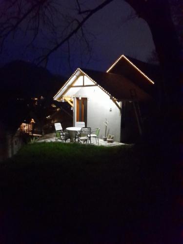 a white house with a table and chairs at night at Kuca za odmor Lola in Ivanjica