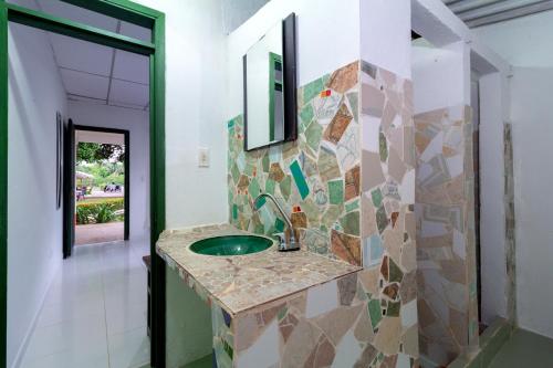 a bathroom with a sink and a mirror on a wall at EcoHotel La Fortuna 