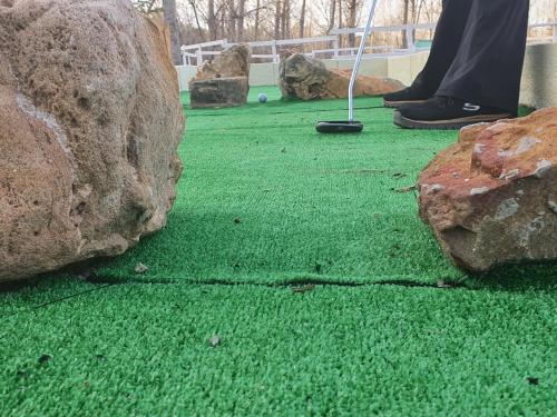 a person playing golf on the grass with rocks at HOTEL MASIA EL MOLINETE in Mora de Rubielos