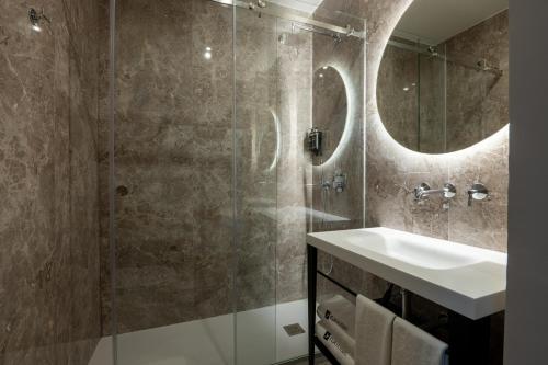 y baño con lavabo y ducha. en Rossio FLH Suites en Lisboa