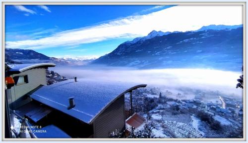 Blick auf eine Stadt im Schnee mit Bergen in der Unterkunft Atmosfera e vista mozzafiato Chalets in Aosta
