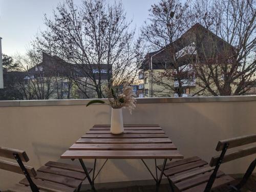 wazon siedzący na drewnianym stole na balkonie w obiekcie Bis zu 6 Personen, Bahnhofs- & Zentrumsnah, Südheide, Netflix und PS4 w mieście Celle