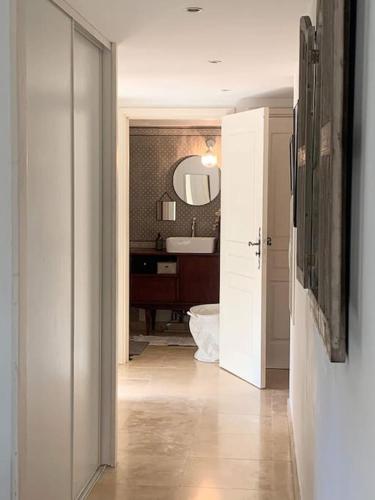 - un couloir avec une salle de bains pourvue d'un lavabo et d'un miroir dans l'établissement Superbe appartement en résidence avec piscine, à La Croix-Valmer