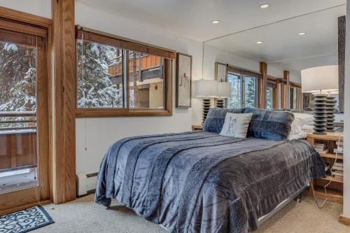 a bedroom with a bed and two windows at Laurelwood Condominiums 304 in Snowmass Village