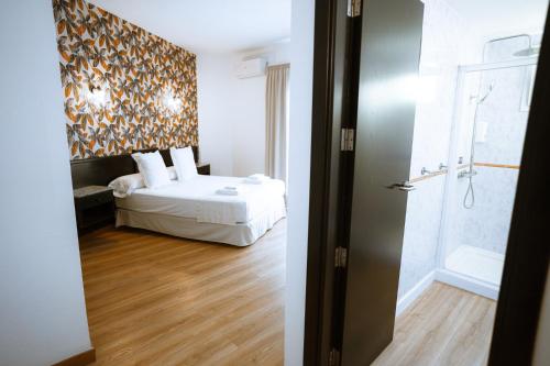 a hotel room with a bed and a bathroom at Hotel Ventus in El Médano