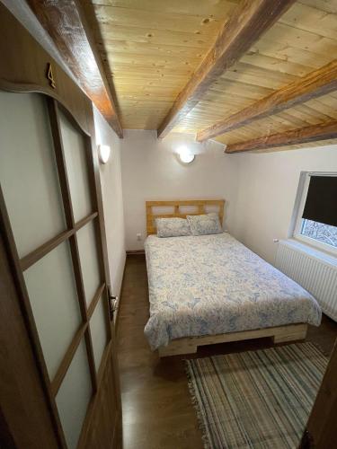 a small bedroom with a bed and a window at Cabana Tudor in Avrig
