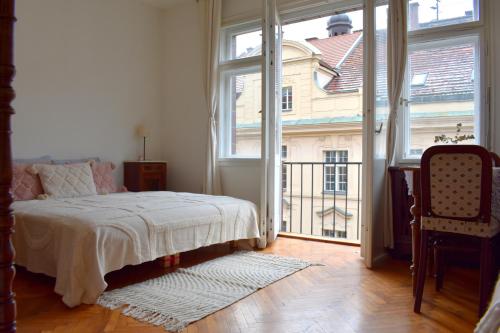 a bedroom with a bed and a large window at Old Town Residence - Konviktská in Prague