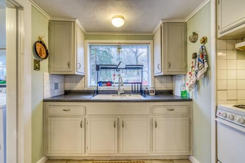 a kitchen with white cabinets and a sink and a window at Cozy Lakefront Cottage Getaway Branson MO. in Branson