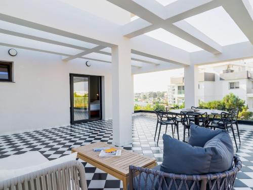 a patio with tables and chairs on a checkered floor at LIV The City Suites ADULTS ONLY in Larnaka