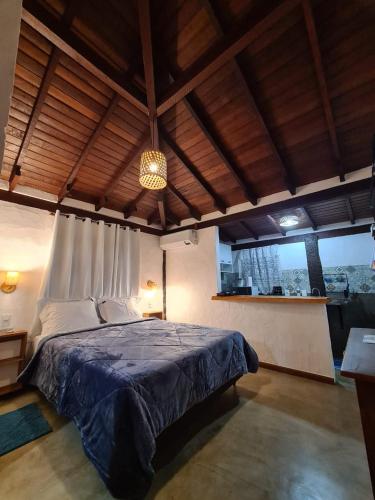 Pouso Araris - Araras, Vale das Videiras في بتروبوليس: غرفة نوم بسرير كبير مع بطانية زرقاء
