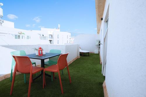 een tafel en stoelen op een balkon met groen gras bij Hotel Ventus in El Médano