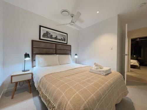 a bedroom with a large bed and a table with a lamp at CBD Cozy 2Beds Apt at Brisbane Tallest building With Free Parking in Brisbane