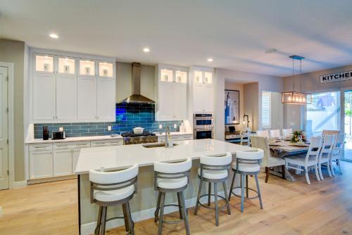 a kitchen with white cabinets and a table and chairs at Luxury Home in Downtown Sarasota, HTD POOL/Hot tub in Sarasota