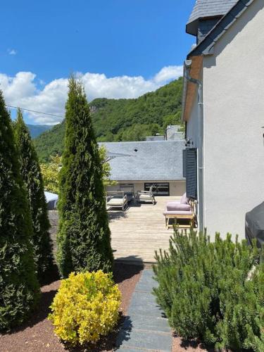 a patio with chairs and trees and a building at Maison 4 à 6 pers tout confort Proche Loudenvielle Balnea Peyragudes in Cazaux-Debat