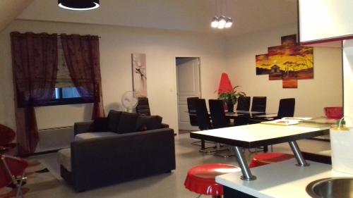 sala de estar con sofá, mesa y sillas en Les granvillaises en Granville
