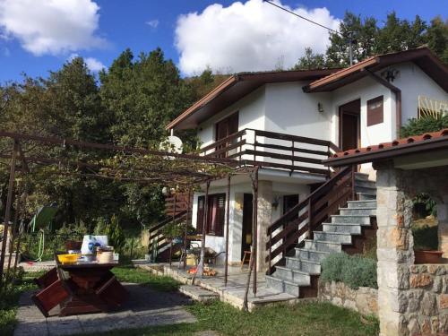 uma casa com escadas e uma mesa em frente em Beautiful holiday cottage DaMa em Nova Gorica