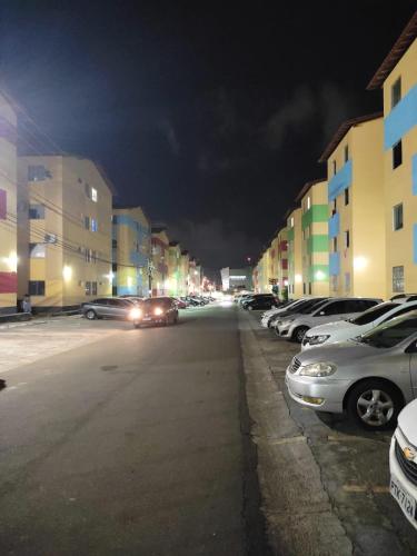 uma rua com carros estacionados num parque de estacionamento à noite em Apartamento Tupy I - Turu em São Luís