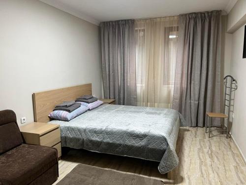 a small bedroom with a bed and a couch at Апартамен в Манастира 3 in Smolyan