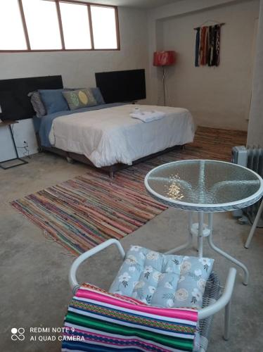 a room with a bed and a table and a bed at CasaHotel Laguna Jauja Airport in Jauja