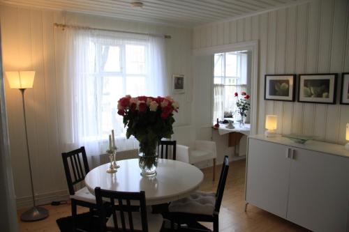 Un comedor con una mesa con un jarrón de flores encima. en Bergstaðastræti Apartment, en Reikiavik