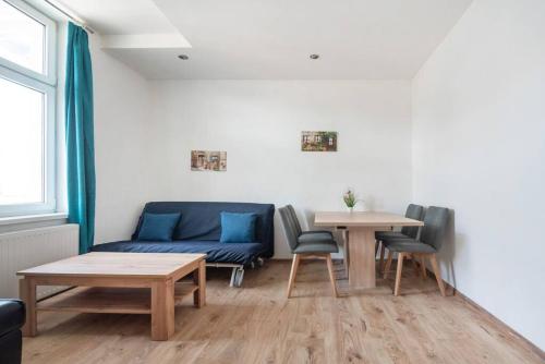 ein Wohnzimmer mit einem blauen Sofa und 2 Tischen in der Unterkunft Lovely serviced apartment Vienna 3km to DT+Balcony in Wien