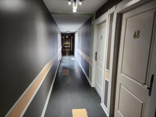 a long corridor with a door and a hallway at Alpine Inn Abbotsford in Abbotsford