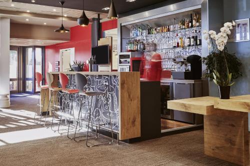 a bar with bar stools in a restaurant at ibis Marseille Provence Aéroport in Marignane