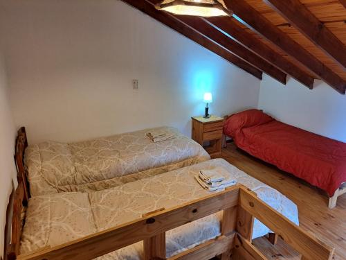 Habitación con 2 camas y mesa. en La Casita del Bosque en Ushuaia