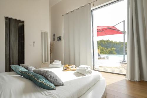 Un dormitorio con una gran ventana con un aro de baloncesto en Splendide Villa ESTEVE piscine démesurée proximité Sarlat, en Sainte-Mondane