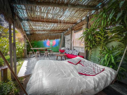 a bedroom with a bed and a patio with plants at Xainã Pousada de Charme in Cumbuco
