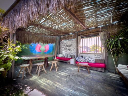 a room with benches and a table and chairs at Xainã Pousada de Charme in Cumbuco