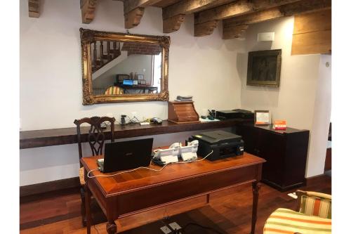 an office with a desk with a laptop and a mirror at Hotel Casa de Familia de San Cristobal in San Cristóbal de Las Casas
