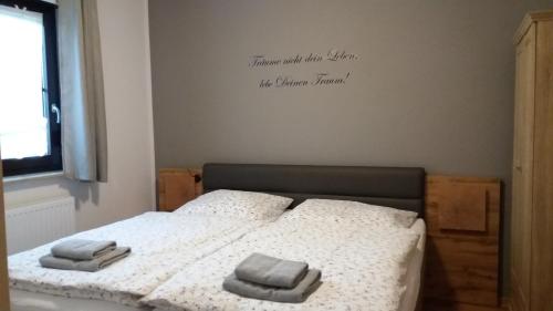 1 dormitorio con 1 cama con 2 toallas en Am Wiesengrund, en Lebus