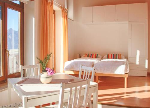 a bedroom with a bed and a table and chairs at Casa S Tomè Nago Torbole in Nago-Torbole