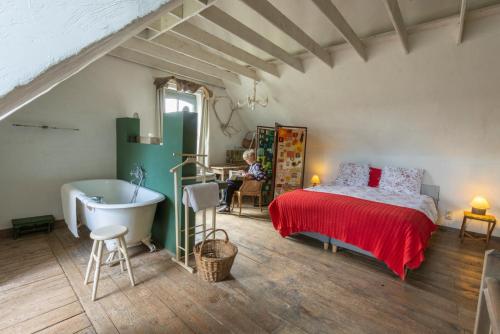 Schlafzimmer mit einem Bett, einer Badewanne und einem Tisch in der Unterkunft Holiday Home Stilleven in Veurne