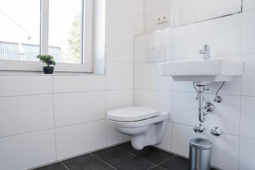 a white bathroom with a toilet and a sink at Buer Appartment in Gelsenkirchen