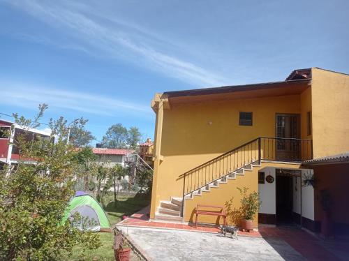 a yellow house with a staircase in front of it at Casa campestre la Posada de Leo in Paipa