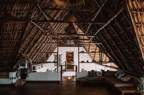 a living room with a couch in a straw building at Casa Zala in El Paredón Buena Vista