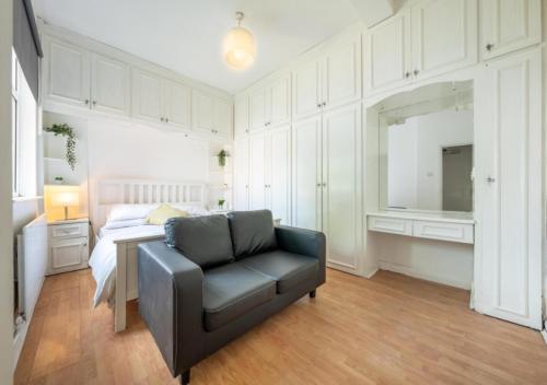 a bedroom with a couch and a bed and a table at Spacious Cricklewood Apartment sleeps 4 in London