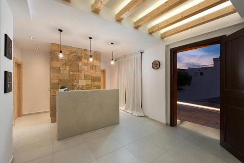 a hallway with a large glass door and a stone wall at Old Town Senses Boutique Hotel in Rhodes Town