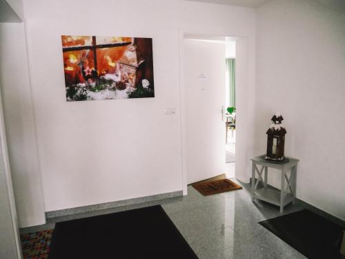 a white hallway with a painting on the wall at Willy´s Ferienzimmer im Tabakdorf Hatzenbühl in Hatzenbühl